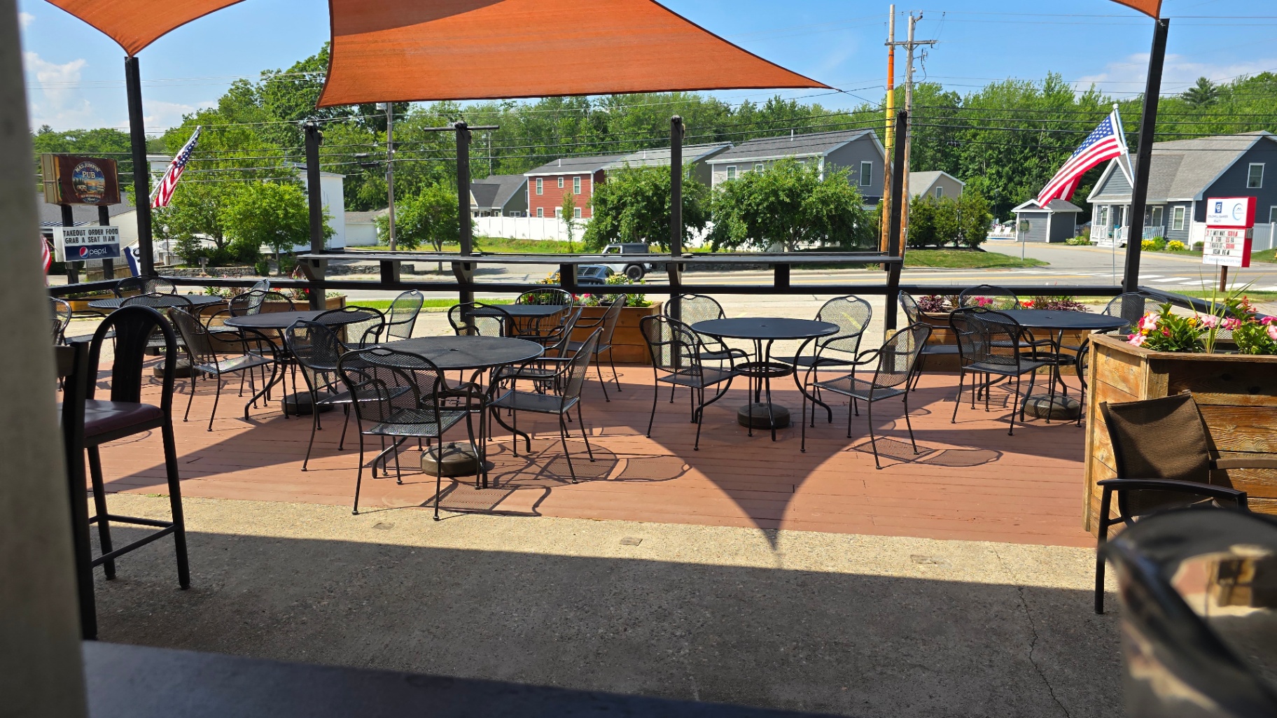 Patio tables under orange shade sails